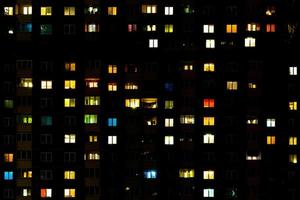 panorama notturno piatto di luce multicolore nelle finestre di edifici a più piani. la vita nelle grandi città foto