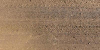 vista dall'alto sulla struttura della strada sterrata con tracce di pneumatici per auto foto