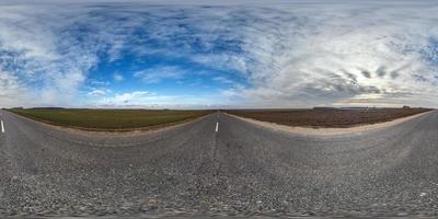 panorama sferico completo senza soluzione di continuità vista angolare a 360 gradi su strada asfaltata senza traffico tra i campi in una giornata di sole con cielo nuvoloso. Panorama a 360 gradi in proiezione equirettangolare, contenuto vr ar foto