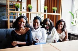 quattro ragazze afroamericane sedute sul tavolo al bar. foto