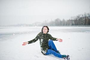 ragazza divertente indossare su felpa verde lunga e jeans, al lago ghiacciato in una giornata invernale. foto