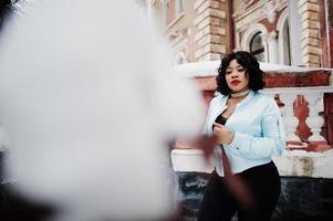 elegante modello afroamericano plus size per le strade della città il giorno d'inverno. foto