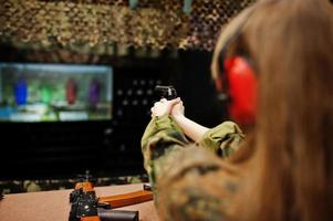 sparando al poligono di tiro. la donna al poligono ha sparato con la pistola. foto