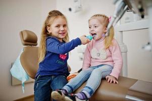 due piccole bambine carine alla poltrona del dentista. bambini dentali. foto