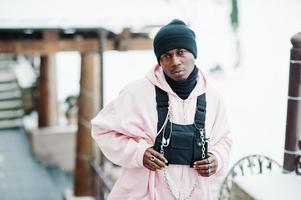 elegante uomo afroamericano in stile urbano in felpa con cappuccio rosa posato al giorno d'inverno. foto