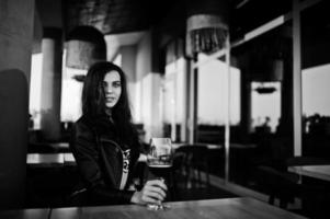 giovane donna riccia godendo il suo vino in un bar. foto