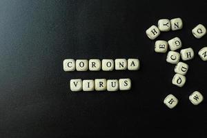 cubo di legno del virus corona su sfondo nero per contenuto medico. foto