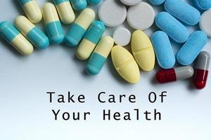 prenditi cura della tua salute testo sul tavolo medico con pillole, compresse e capsule foto