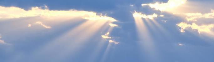 i raggi del sole sfondano le nuvole azzurre. lo sfondo del cielo. foto