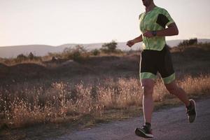 atleta di triathlon che corre durante l'allenamento mattutino foto