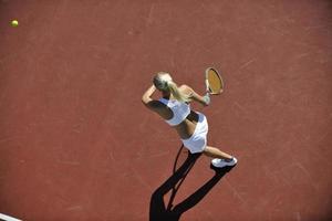 giovane donna giocare a tennis all'aperto foto