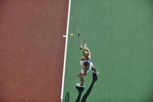 giovane donna giocare a tennis all'aperto foto