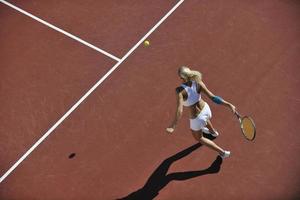 giovane donna giocare a tennis all'aperto foto