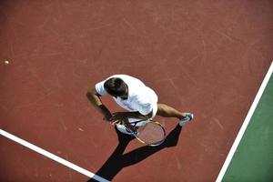 il giovane gioca a tennis foto