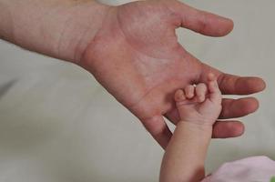 grande mano dell'uomo che tiene piccola mano del bambino foto