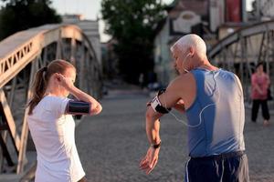 coppia che fa jogging che pianifica il percorso di corsa e imposta la musica foto