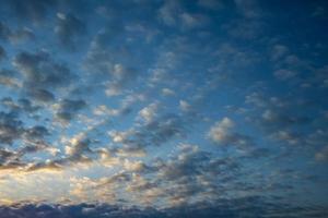 sfondo del cielo blu scuro con minuscole nuvole a strisce di cirrus di strati. schiarimento serale e bel tempo ventoso foto