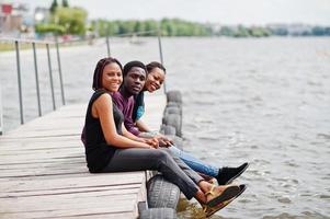 tre amici afroamericani posati sul molo. foto