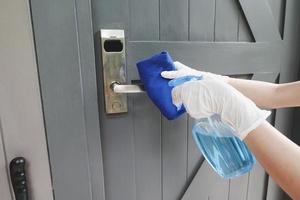 pulire le maniglie delle porte con un antisettico durante un'epidemia virale foto
