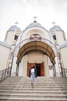 donna afroamericana all'aperto contro la chiesa e prega Dio. concetto di fede, spiritualità e religione. foto