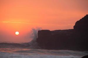 tramonto sopra il tempio indù pura tanah lot, bali, indonesia foto