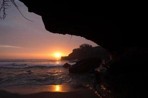 tramonto sopra il tempio indù pura tanah lot, bali, indonesia foto