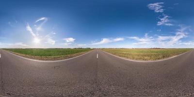 panorama sferico completo senza soluzione di continuità vista angolare a 360 gradi su strada asfaltata senza traffico tra i campi la sera prima del tramonto con cielo nuvoloso. Panorama a 360 gradi in proiezione equirettangolare, contenuto vr ar foto