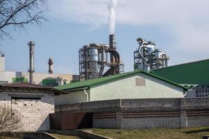 tubi della segheria dell'impianto di impresa di lavorazione del legno vicino al fiume. concetto di inquinamento atmosferico. paesaggio industriale inquinamento ambientale rifiuti di centrale termica foto