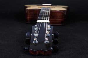 piroli di sintonia su macchina in legno testa di chitarra acustica a sei corde su sfondo nero foto