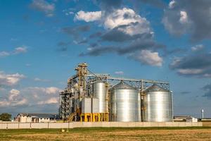 silos d'argento su impianto di produzione agro per la lavorazione di essiccamento, pulitura e stoccaggio di prodotti agricoli, farina, cereali e grano. ascensore del granaio foto