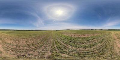 panorama hdri sferico completo senza soluzione di continuità vista a 360 gradi tra i campi in una giornata primaverile con alone nel cielo sereno in proiezione equirettangolare, pronto per contenuti di realtà virtuale vr ar foto