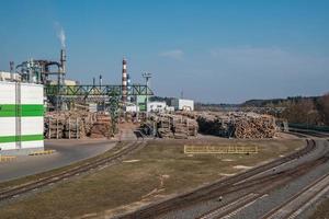 tubi della segheria dell'impianto di impresa di lavorazione del legno vicino al fiume. concetto di inquinamento atmosferico. paesaggio industriale inquinamento ambientale rifiuti di centrale termica foto