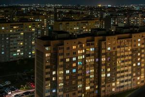 panorama notturno di luce nelle finestre di un edificio a più piani. vita in una grande città foto