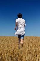 giovane donna nel campo di grano in estate foto