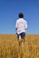 giovane donna nel campo di grano in estate foto