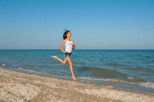 la ragazza corre sul mare foto