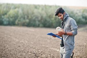 agronomo agricoltore del sud asiatico con pala che ispeziona il suolo nero. concetto di produzione agricola. foto