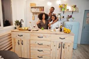 tre amici afroamericani che trascorrono del tempo in cucina con il vino. i neri si rilassano a casa. foto