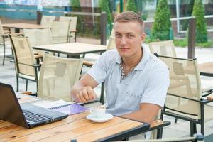 giovane seduto al caffè foto