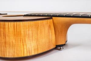 struttura in legno del ponte inferiore di una chitarra acustica a sei corde su sfondo bianco. forma di chitarra foto