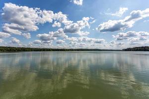 riflesso nell'acqua di un grande lago forestale foto