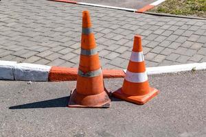 cono di pericolo di traffico arancione bianco sulla riparazione della strada asfaltata foto