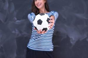 donna che tiene un pallone da calcio davanti al tavolo da disegno di gesso foto