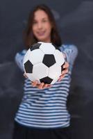 donna che tiene un pallone da calcio davanti al tavolo da disegno di gesso foto