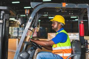 lavoratore su carrello elevatore, lavoratori manuali che lavorano in magazzino, autista lavoratore presso il caricatore di carrelli elevatori del magazzino lavora foto