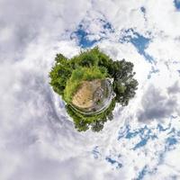 trasformazione del piccolo pianeta del panorama sferico a 360 gradi. vista aerea astratta sferica in campo con bellissime nuvole fantastiche. curvatura dello spazio. foto