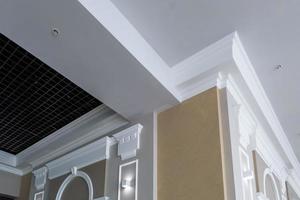 particolare del soffitto ad angolo con intricate modanature a corona su colonna con faretto foto