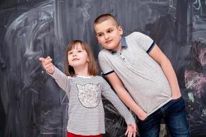 ragazzo e bambina in piedi davanti alla lavagna foto