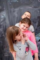 gruppo di bambini in piedi davanti alla lavagna foto