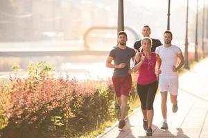 gruppo di giovani che fanno jogging in città foto